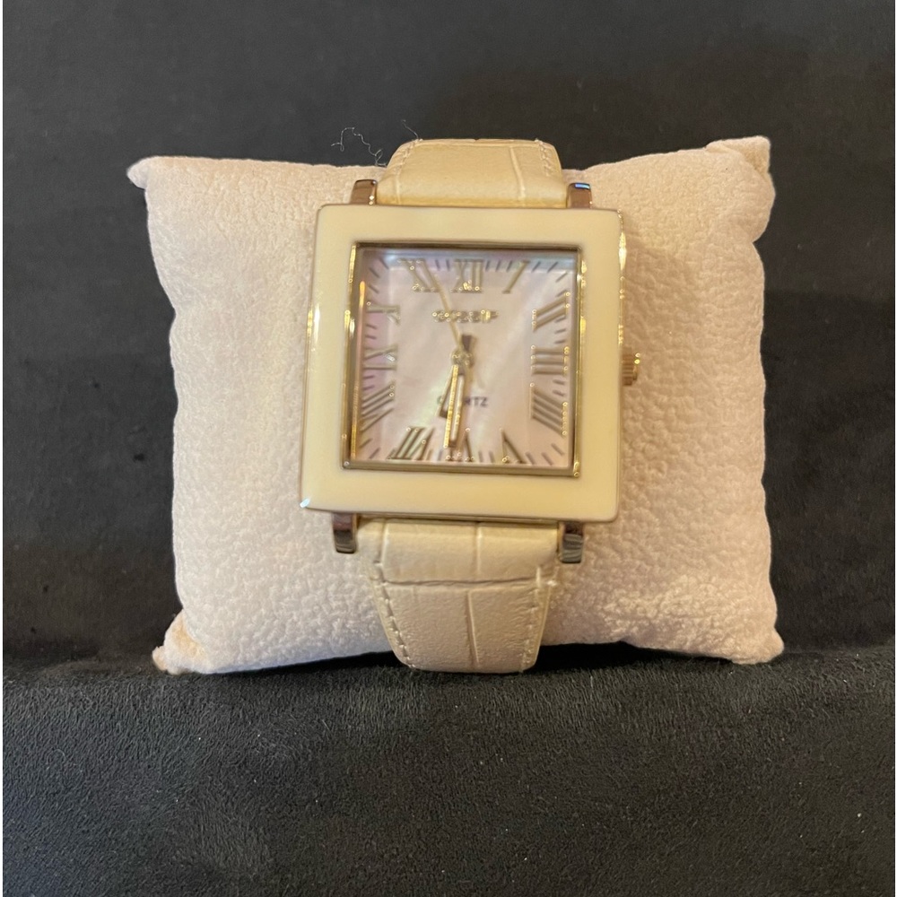 Gossip wrist watch, cream colored band with a pearl iridescence face.